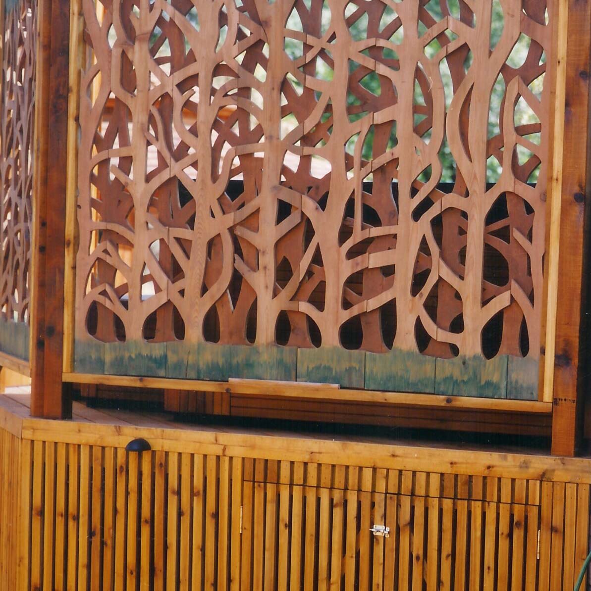 A decorative wooden screen with intricate patterns, partially conceals a person. Natural light filters through the geometric design, creating dynamic shadows.